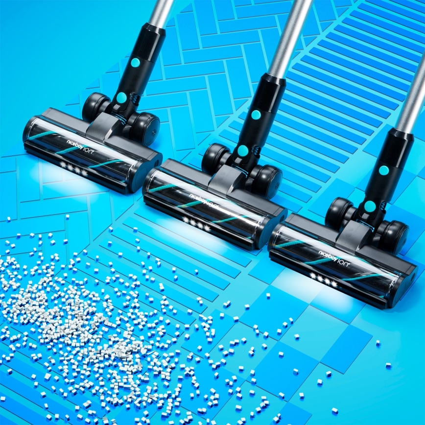Tri vysávače Niceboy Ion čistia svetlomodrú plochu posiatu malými bielymi kockami. Vysávače sú umiestnené pod uhlom, pričom sa zdá, že vysávajú.