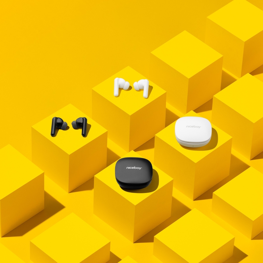 Dve sady bezdrôtových slúchadiel, biela a čierna, ležia na žltých kockách. Ku každej sade patrí nabíjacie puzdro s nápisom „niceboy“.