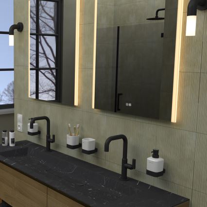 Dvojité umývadlo s čiernou doskou a dvoma batériami je umiestnené v modernej kúpeľni. Na stene nad ním je zavesené osvetlené zrkadlo s displejom. Na stene sú aj nástenné držiaky na mydlo a kefky na zuby.