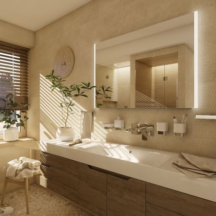 Umývadlo s batériou a doplnkami je umiestnené na drevenom nábytku v kúpeľni. Nad umývadlom je zrkadlo s LED osvetlením. V pozadí sú viditeľné žalúzie na okne a rastliny.