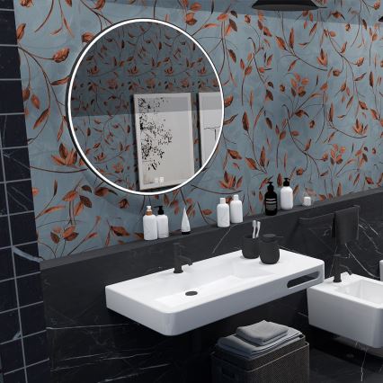 Kúpeľňové umývadlo s okrúhlym zrkadlom s podsvietením sa nachádza na tmavej doske pred stenou s tapetou s hnedými listami na modrom podklade. Vedľa umývadla sú hygienické potreby a uteráky v košíku.