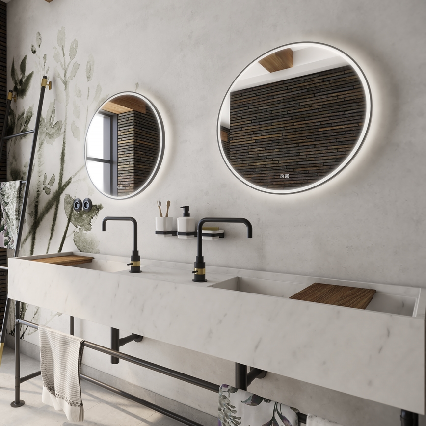 Dvojité umývadlo z mramoru s dvoma batériami je umiestnené v kúpeľni. Nad umývadlom visia dva okrúhle osvetlené zrkadlá. Stenu zdobia dekoratívne tapety s rastlinnou potlačou a tmavý obklad z dreva.