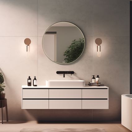 Okrúhle zrkadlo so svetlom je umiestnené nad umývadlom v kúpeľni. Vedľa zrkadla sú dve nástenné lampy. Pod zrkadlom je umývadlo s dvoma dávkovačmi mydla a nádobkou na doplnky.