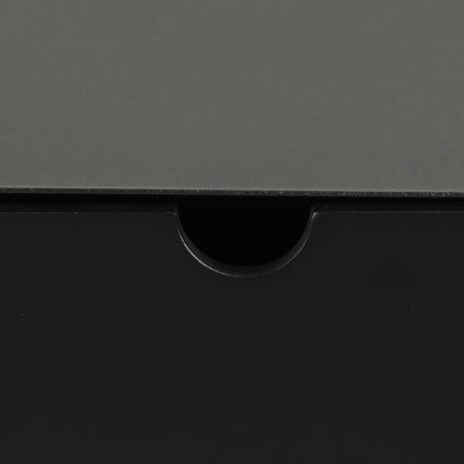 Šuplík je čiastočne otvorený. Viditeľná je tmavosivá vrchná časť a čierna spodná časť šuplíka. Vyrezaný otvor slúži na uchopenie a otvorenie šuplíka.