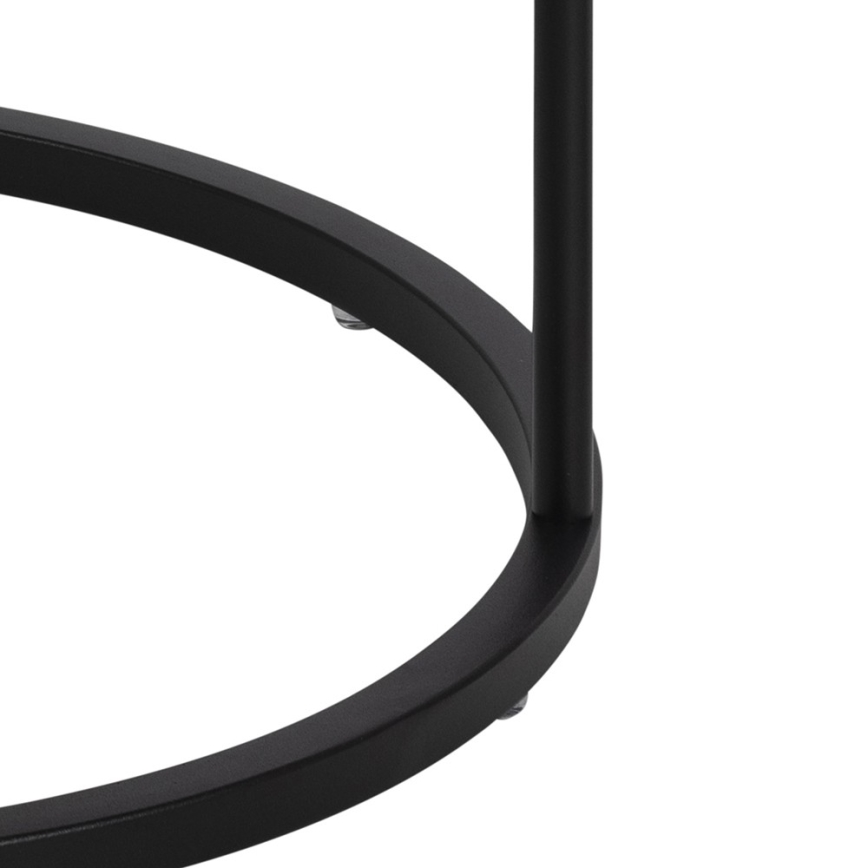 Čierny kovový stolík s kruhovou podstavou a jednou stredovou nohou stojí na štyroch malých gumených podložkách.