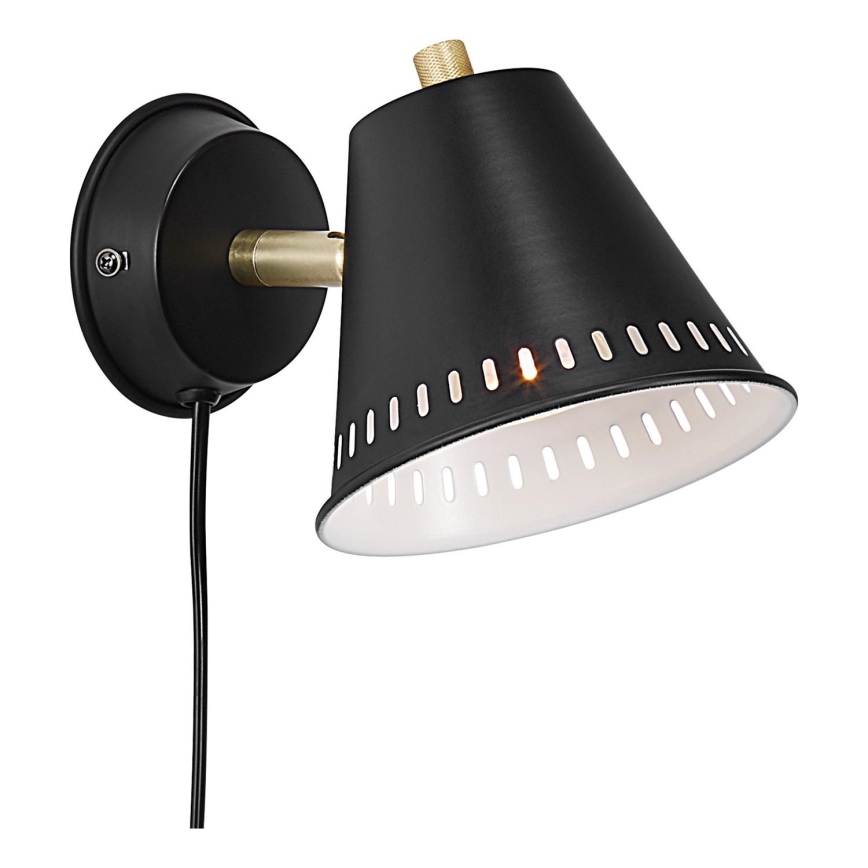 Čierna nástenná lampa s kužeľovitým tienidlom, s otvormi a bielym vnútorným povrchom, je pripojená k stene káblom a svieti.