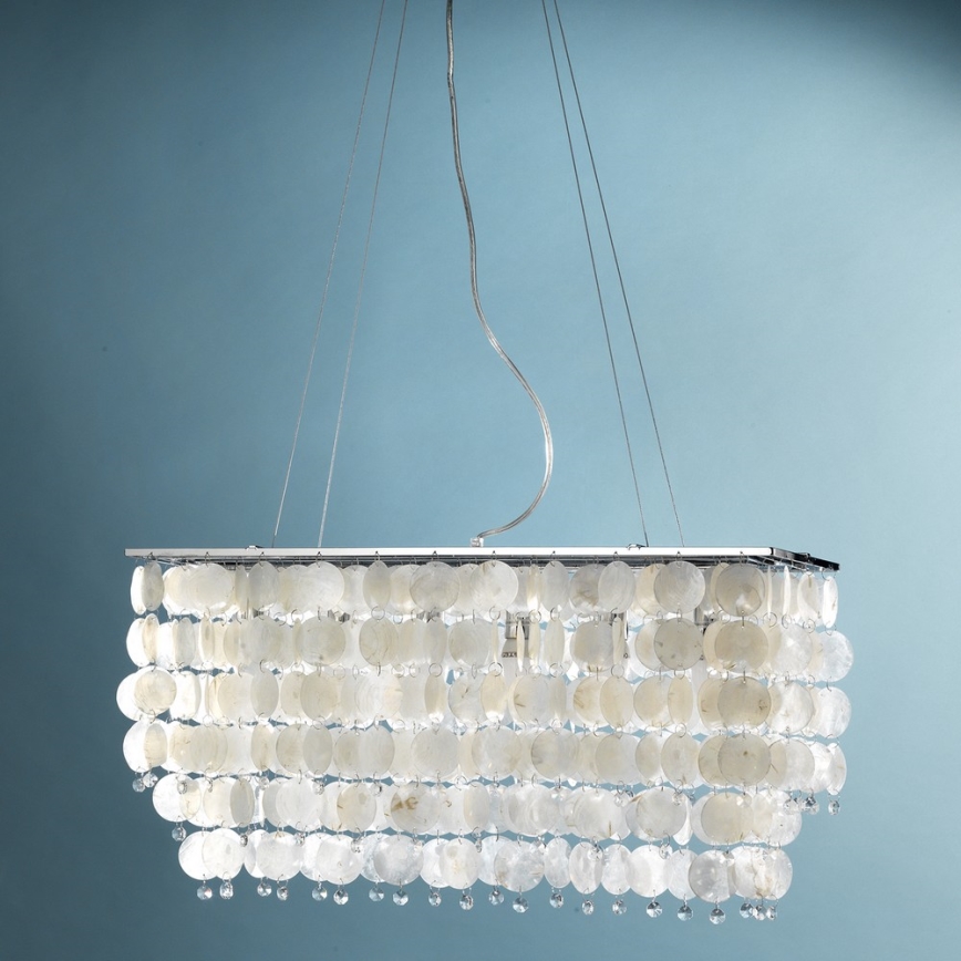 Stropné svietidlo visí zo stropu. Je zhotovené z mnohých malých, oválnych, priesvitných prvkov a kovového rámu. Svietidlo je pred modrým pozadím.