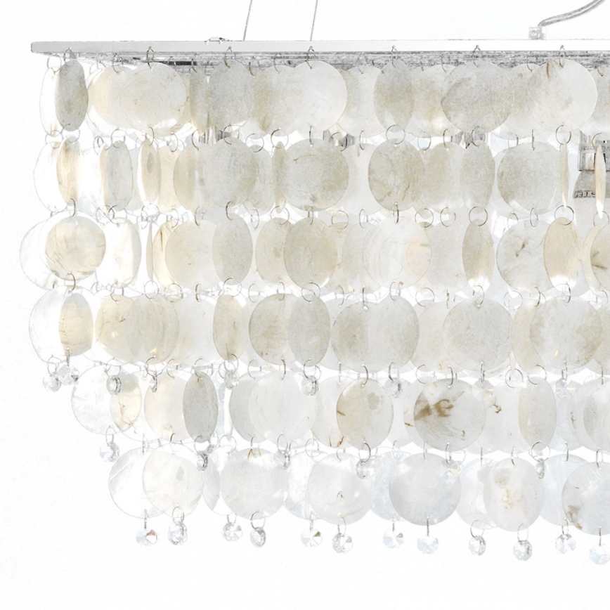 Stropná lampa visí zhora. Je zložená z mnohých prekrývajúcich sa, okrúhlych, mliečne bielych prvkov, ktoré sú zavesené na kovových držiakoch. Spodná časť lampy je ozdobená drobnými krištáľovými kamienkami.