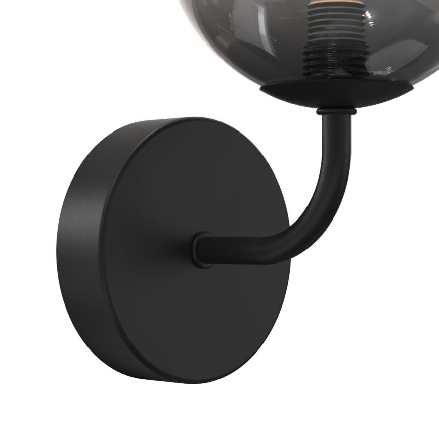 Nástenná lampa s guľovou sklenenou tienidlom tmavosivej farby sa pripevňuje na stenu pomocou čiernej kovovej konzoly. Lampa je osvetlená žiarovkou s viditeľným závitom.