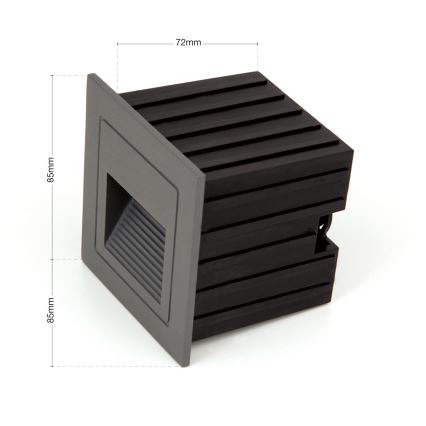 Svietidlo s rozmermi 85mm x 85mm x 72mm je umiestnené na bielom pozadí. Svietidlo je sivé s čiernym zadným krytom. Má štvorcový tvar s výrezom na vyžarovanie svetla.