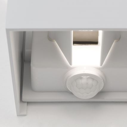 Snímač pohybu je zabudovaný v bielej nástenní lampe. Snímač je umiestnený v spodnej časti lampy a svetlo svieti zhora. Lampa je pripevnená na stene.