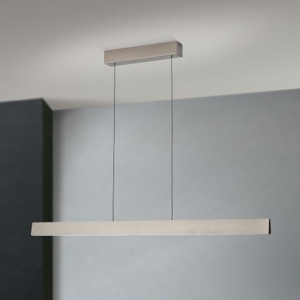Dlhá, obdĺžniková LED lampa visí zo stropu na dvoch kábloch. Je umiestnená v miestnosti s bledomodrou stenou.