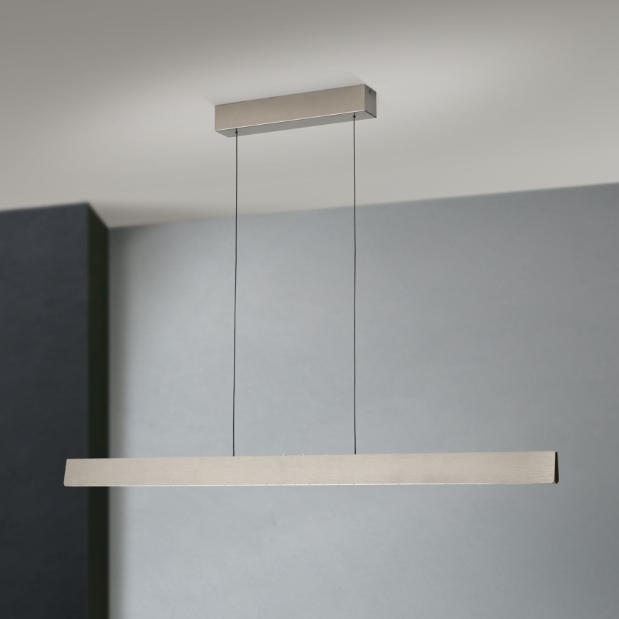 Dlhá, obdĺžniková LED lampa visí zo stropu na dvoch kábloch. Je umiestnená v miestnosti s bledomodrou stenou.