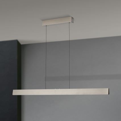 Dlhá, obdĺžniková LED lampa visí zo stropu na dvoch kábloch. Je umiestnená v miestnosti so šedými stenami.