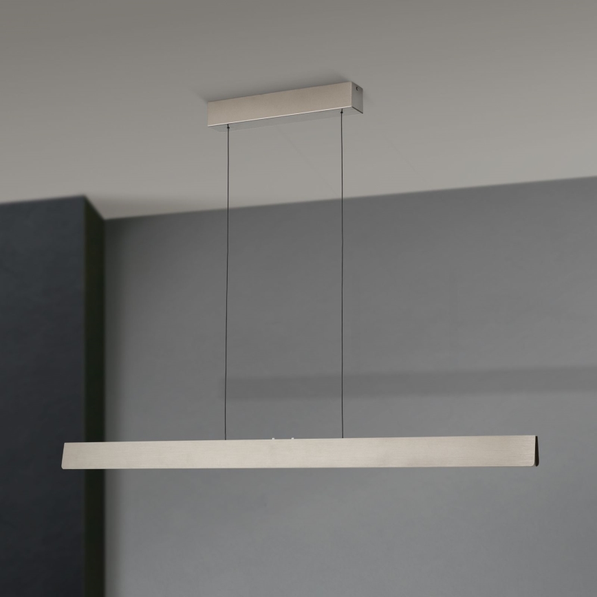 Dlhá, obdĺžniková LED lampa visí zo stropu na dvoch kábloch. Je umiestnená v miestnosti so šedými stenami.