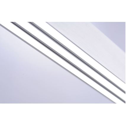 Dve paralelné LED lišty sú umiestnené na strope. Lišty sú zapustené a vyžarujú svetlo. Svetlo je biele, pozadie je svetlofialové.