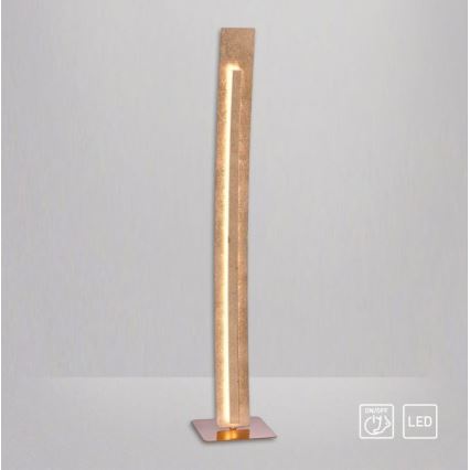 Stojacia lampa svieti. Je vysoká a úzka, vyrobená z béžového materiálu s vnútorným LED osvetlením. Má kovovú podstavu. Symboly na obrázku označujú zapínanie/vypínanie a LED zdroj svetla.