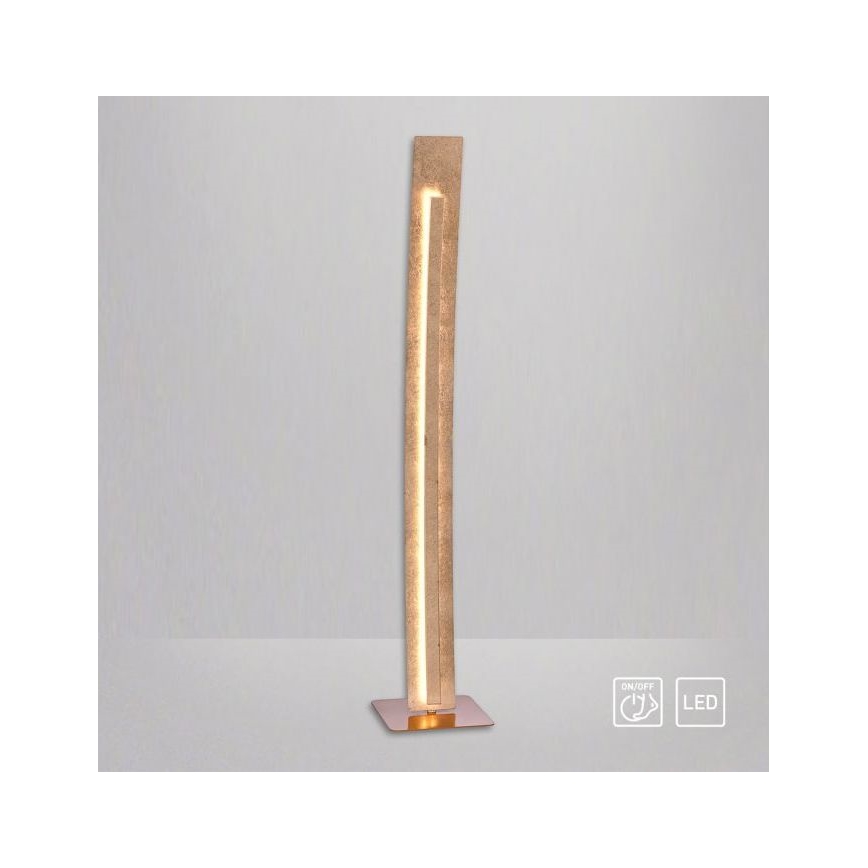 Stojacia lampa svieti. Je vysoká a úzka, vyrobená z béžového materiálu s vnútorným LED osvetlením. Má kovovú podstavu. Symboly na obrázku označujú zapínanie/vypínanie a LED zdroj svetla.