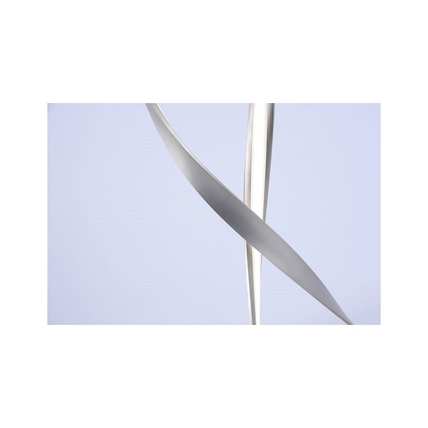 Dve kovové pásky sa prepletajú a vytvárajú abstraktný tvar pred svetlosivým pozadím.