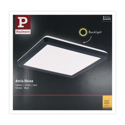 Štvorcové svietidlo Atria Shine od Paulmann svieti. Má čierny rám a teplú bielu farbu svetla (3000 K), výkon 11,2W a svetelný tok 1360 lm. Balenie ukazuje svietidlo s podsvietením.