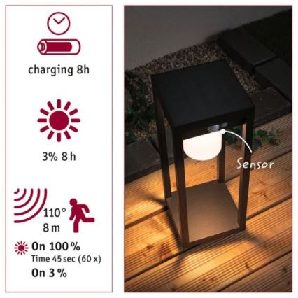 Solárna záhradná lampa svieti na drevenej terase. Lampa má senzor pohybu s dosahom 8 metrov a uhlom 110°. Nabíjanie trvá 8 hodín, svieti na 100% jasu 45 sekúnd (60x) a na 3% jasu 8 hodín.