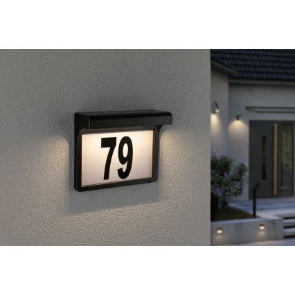 Svietiaca tabuľka s číslom 79 je pripevnená na vonkajšiu stenu domu. Tabuľka je osvetlená a je súčasťou exteriérového osvetlenia domu.