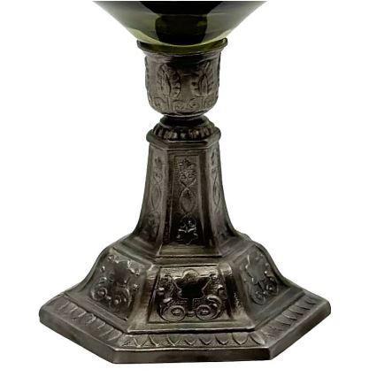 Stojan s tmavozelenou sklenenou misou stojí na osmiuholníkovom podstavci. Podstavec a stonka sú zdobené reliéfnymi ornamentmi.
