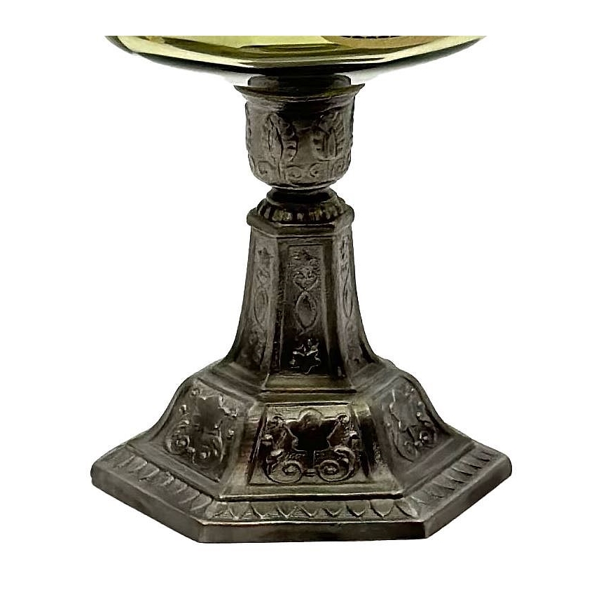 Stojan s misou z tmavého kovu s ozdobnými výrezmi stojí na bielom pozadí. Miska je svetlejšia, zlatistej farby. Stojan má viacúrovňovú podstavu s vyrezávanými ornamentmi.