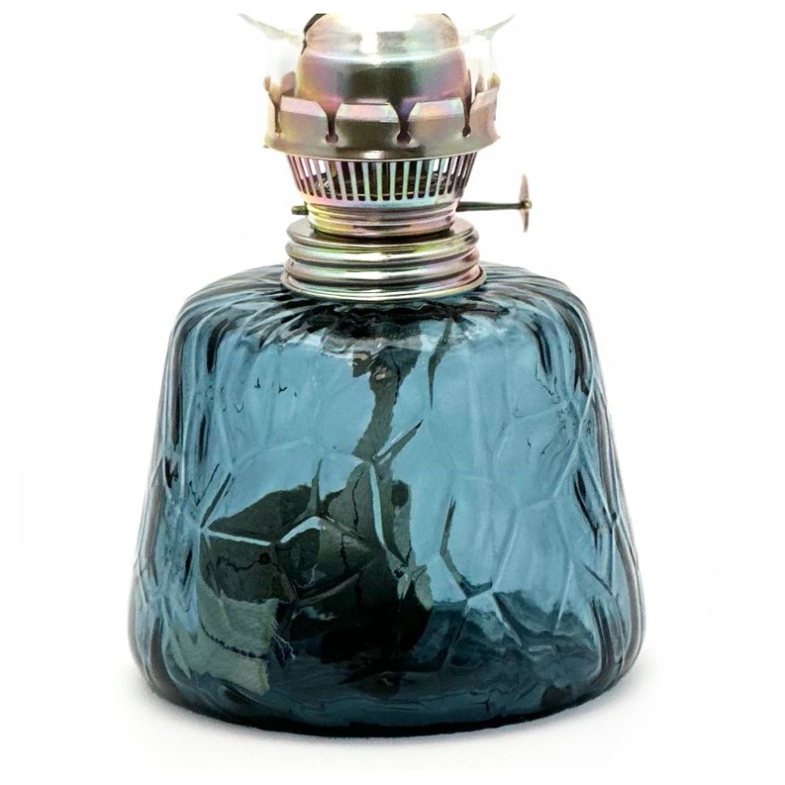 Modrá olejová lampa s reliéfnym skleneným telom a kovovou nádržkou stojí na bielom pozadí.