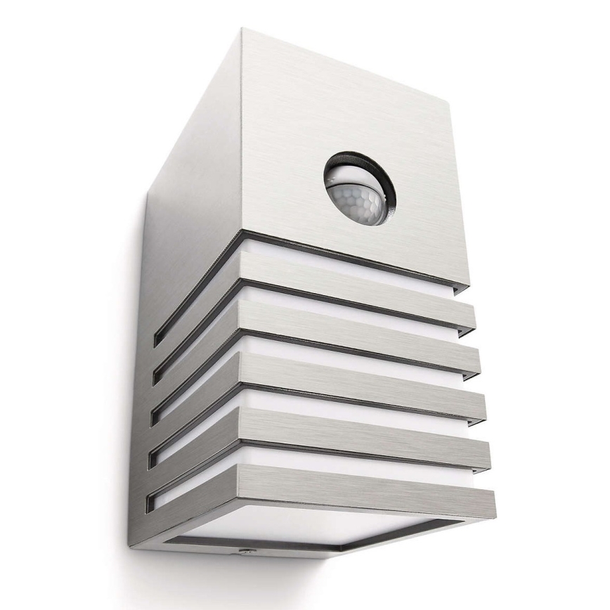 Stĺpcové vonkajšie svietidlo s pohybovým senzorom je pripevnené na stenu. Svietidlo je kovové, striebornej farby, s horizontálnymi drážkami.