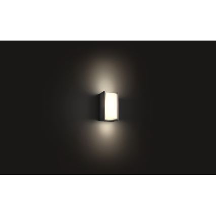 Svietidlo svieti na stene. Je obdĺžnikového tvaru s matným difúzorom. Prostredie je tmavé.