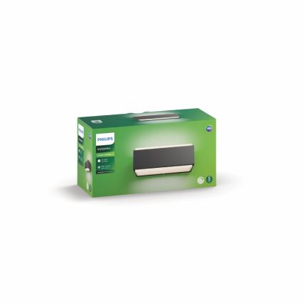 Vonkajšie nástenné svietidlo Philips myGarden je zobrazené v zelenej krabici. Svietidlo je tmavosivé s teplým bielym svetlom. Krabica obsahuje informácie o produkte.