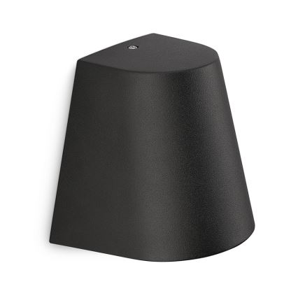 Čierna nástenná lampa s kužeľovitým tienidlom je pripevnená na stene. Lampa je umiestnená na bielom pozadí.