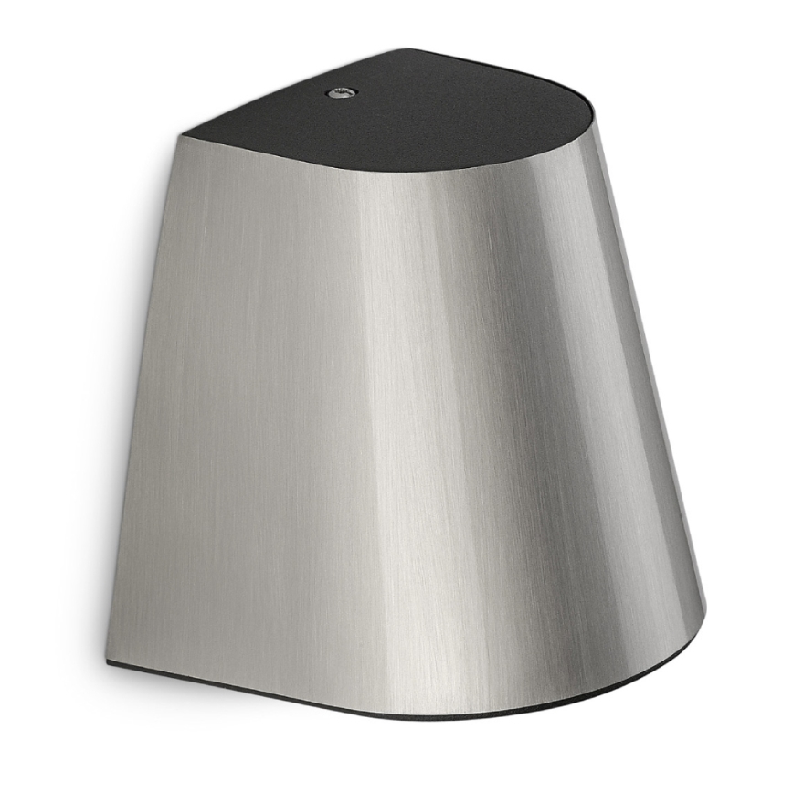 Strieborná nástenná lampa s tmavosivým vrchnákom je pripevnená na stenu. Svetlo je smerované nadol. Lampa má asymetrický tvar.