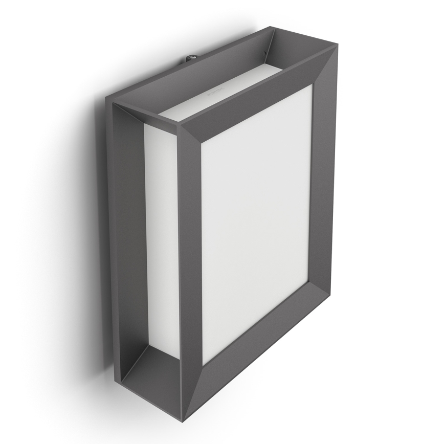 Svietidlo je pripevnené na stene. Má štvorcový tvar s tmavosivým rámom a bielym svetlom. Nachádza sa v jednoduchom bielom prostredí.