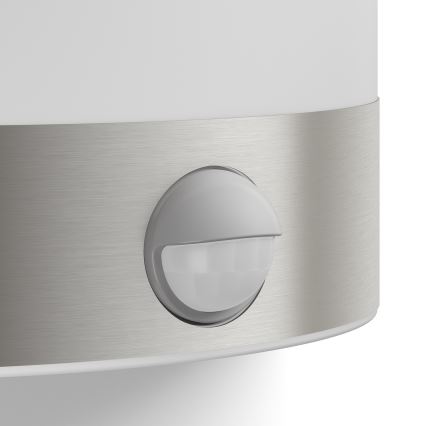 Senzor pohybu detekuje pohyb. Je umiestnený na kovovom páse, ktorý je súčasťou steny svietidla. Svietidlo je biele, s kovovou časťou.