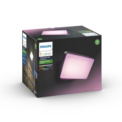 Vonkajší nástenný reflektor Philips Hue Discover svieti jemne ružovým svetlom. Je zabalený v čiernej krabici s popisom: Philips Hue, White and color ambiance, Outdoor Floodlight Discover, warm white, cool daylight, 16 miliónov farieb.