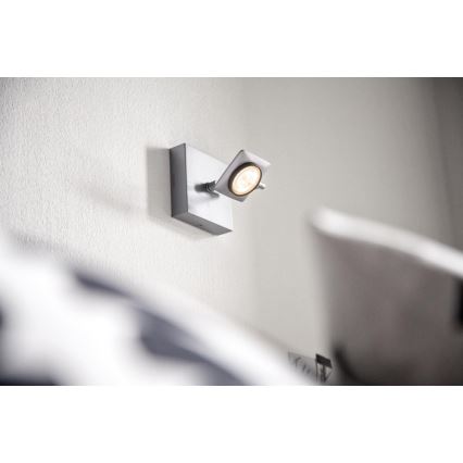 Svietidlo svieti na stene. Je otočné a pripevnené na štvorcovom podstavci. Nachádza sa v blízkosti postele.