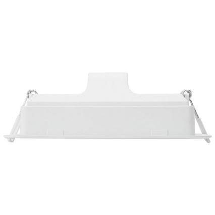 Biela obdĺžniková nástenná lampa je umiestnená na bielom pozadí. Lampa je pripevnená k stene pomocou kovových sponiek.