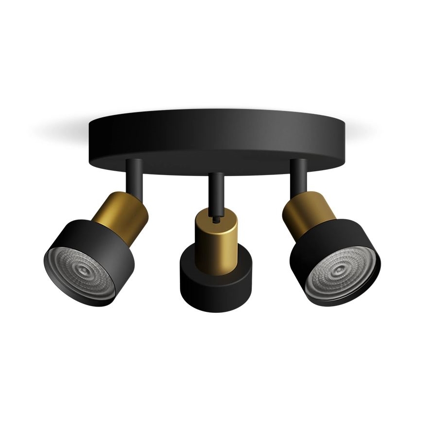 Trojramenné stropné svietidlo s čiernym základom a zlatými prvkami je pripevnené k stropu. Tri nastaviteľné reflektory smerujú dopredu. Svietidlo je zobrazené na bielom pozadí.