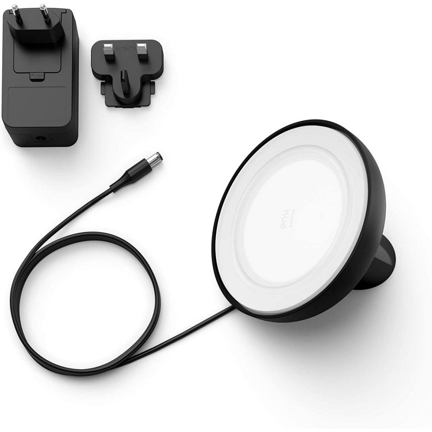 Bezdrôtová nabíjačka Philips Hue je pripojená k sieťovému adaptéru káblom. Súčasťou je aj sieťová zástrčka. Na bielom pozadí.