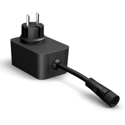 Čierna sieťová zástrčka s káblom sa pripája k elektrickej sieti. Zástrčka má tvar kvádra a je vybavená trojpinovým konektorom typu C. Kábel vyčnieva z boku a končí konektorom. Prostredie je svetlé, na bielom pozadí.