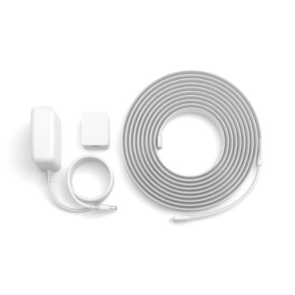 LED pásik je zrolovaný na bielom pozadí. Súčasťou sady je aj sieťový adaptér, ovládač a krátky pripojovací kábel. Všetky komponenty sú biele.