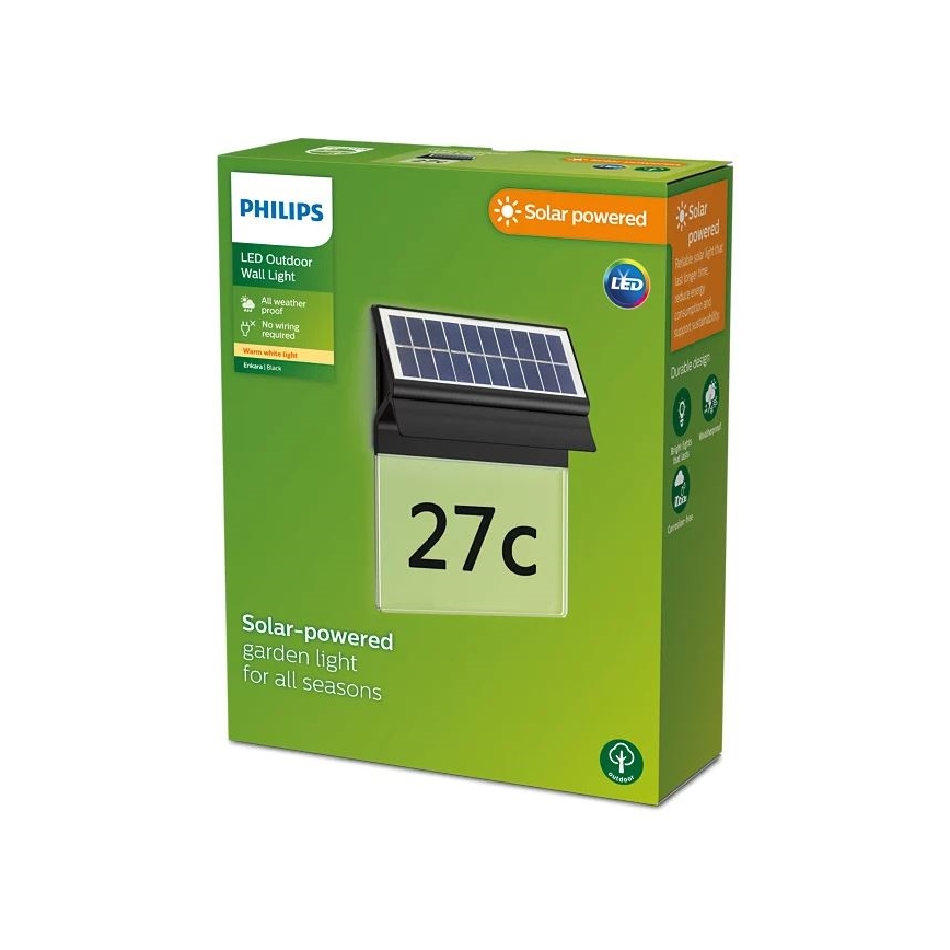Solárna záhradná lampa Philips s číslom 27c je zobrazená na obale. Lampa je pripevnená na stene a je napájaná solárnym panelom. Balenie oznamuje, že je odolné voči poveternostným vplyvom, nevyžaduje zapojenie do siete a vydáva teplé biele svetlo.