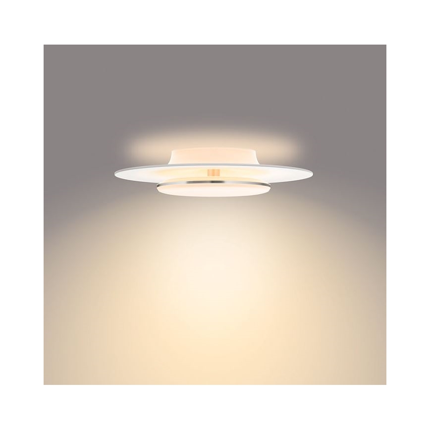 Svietidlo svieti na svetlohnedom pozadí. Má dva biele disky, jeden menší na vrchu druhého väčšieho. Medzi nimi je úzky kovový prstenec.