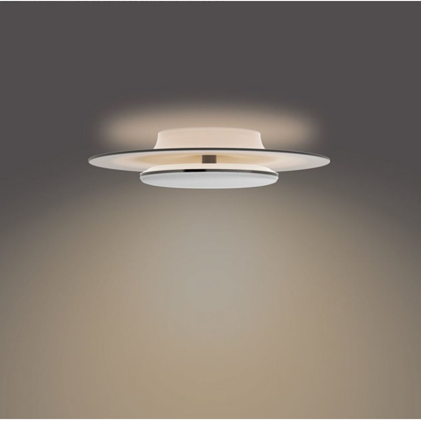 Svietidlo svieti na strope. Dve ploché, kruhové dosky, horná priesvitná, dolná biela, sú navzájom prepojené. Svetlo sa šíri smerom dole, osvetľujúc okolité steny.