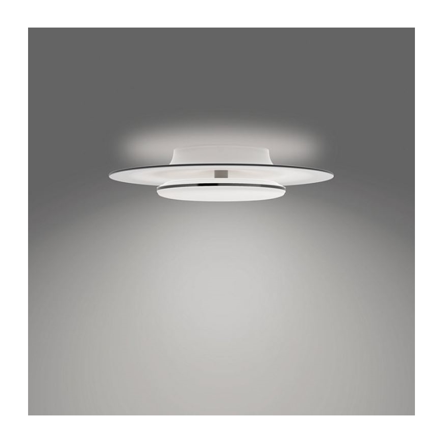 Svietidlo svieti na sivom pozadí. Skladá sa z dvoch bielych, plochých, kruhových prvkov, horný je väčší a mierne prehnutý, spodný je menší a plochý. Medzi nimi je úzky, tmavý prstenec. Svietidlo je pripevnené k stropu.