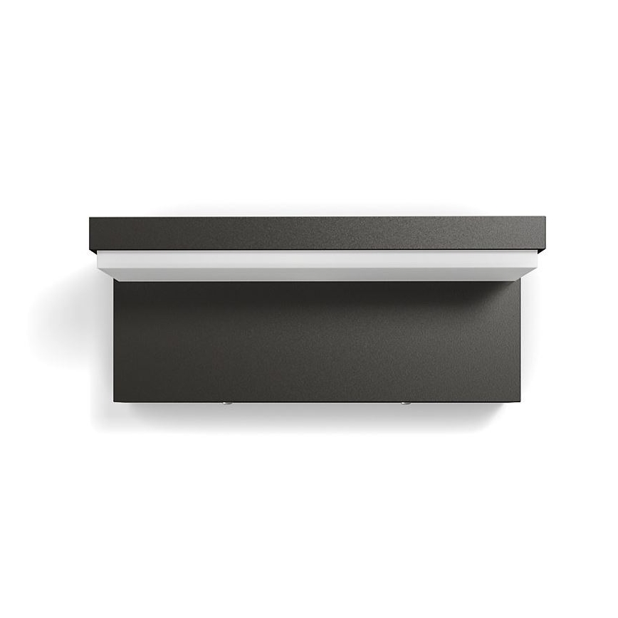 Svietidlo je pripevnené na stene. Svietidlo má tmavosivú farbu a v hornej časti úzky biely svetelný pás. Svietidlo je zobrazené zhora.