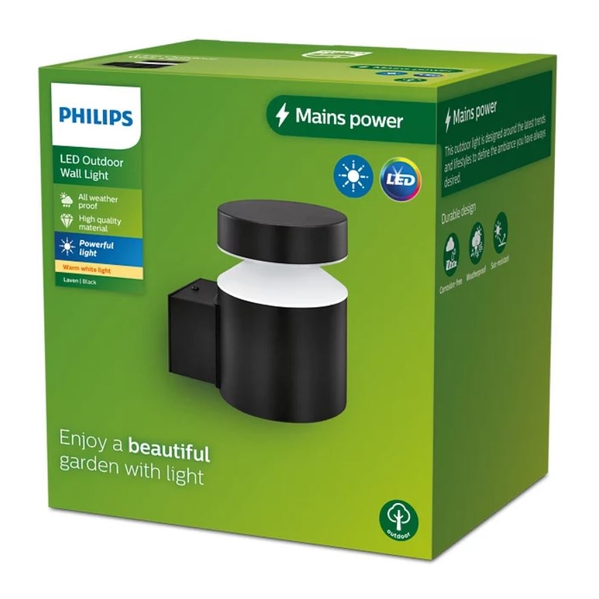Čierna LED nástenná lampa Philips svieti. Je zabalená v zelenej krabici s popisom: LED Outdoor Wall Light, Mains power, All weather proof, High quality material, Powerful light, Warm white light, Laven|Black, a Enjoy a beautiful garden with light.