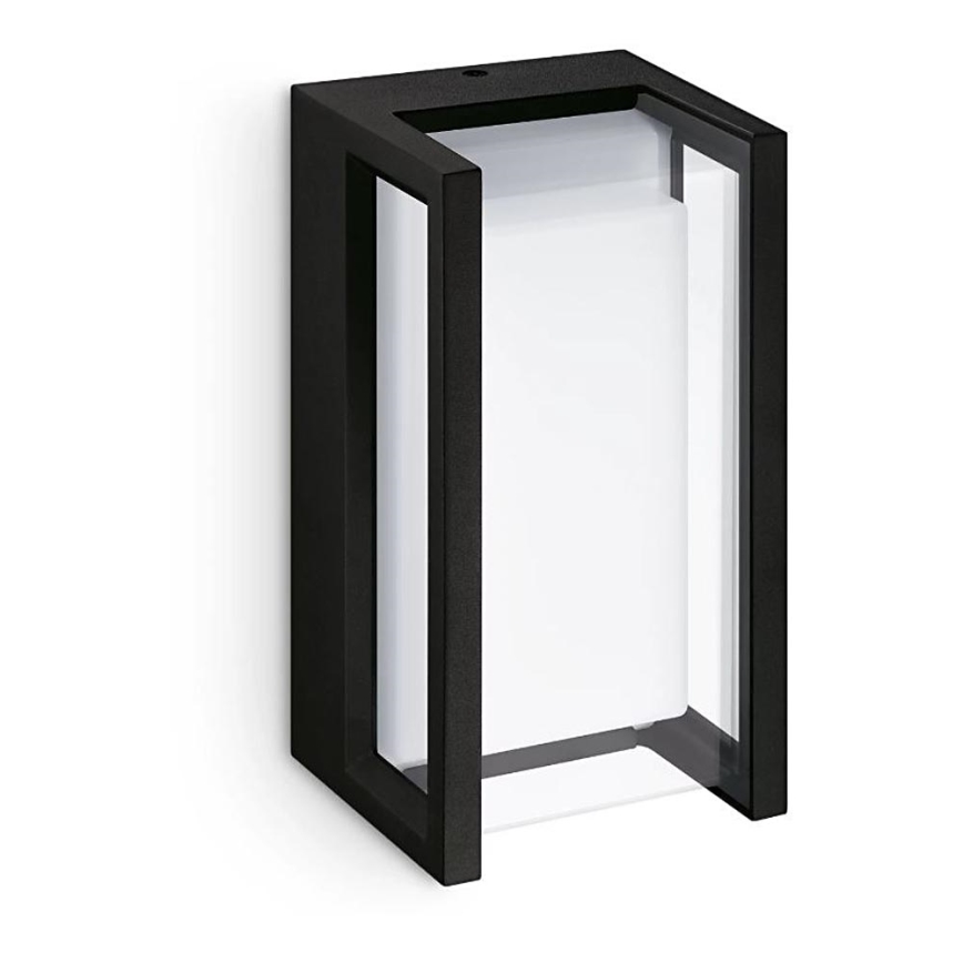 Čierny vonkajší nástenný svietidlo s priehľadným krytom svieti. Je pripevnený na stene, na bielom pozadí.